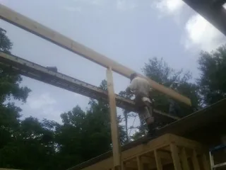 Carpenter setting a ridge beam over a new addition frame — Ice Dam Removal by Roofing Brothers in Idledale