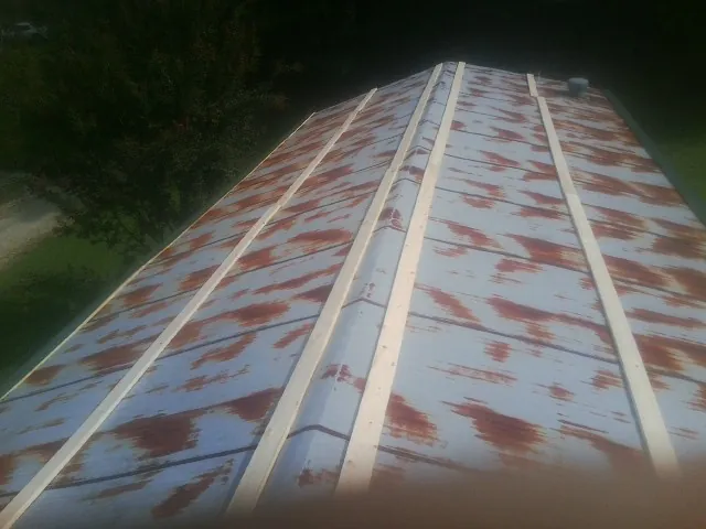 Rusted metal roof panels with new wood purlins before replacement — Storm Damage Roof Repair in Idledale by Roofing Brothers