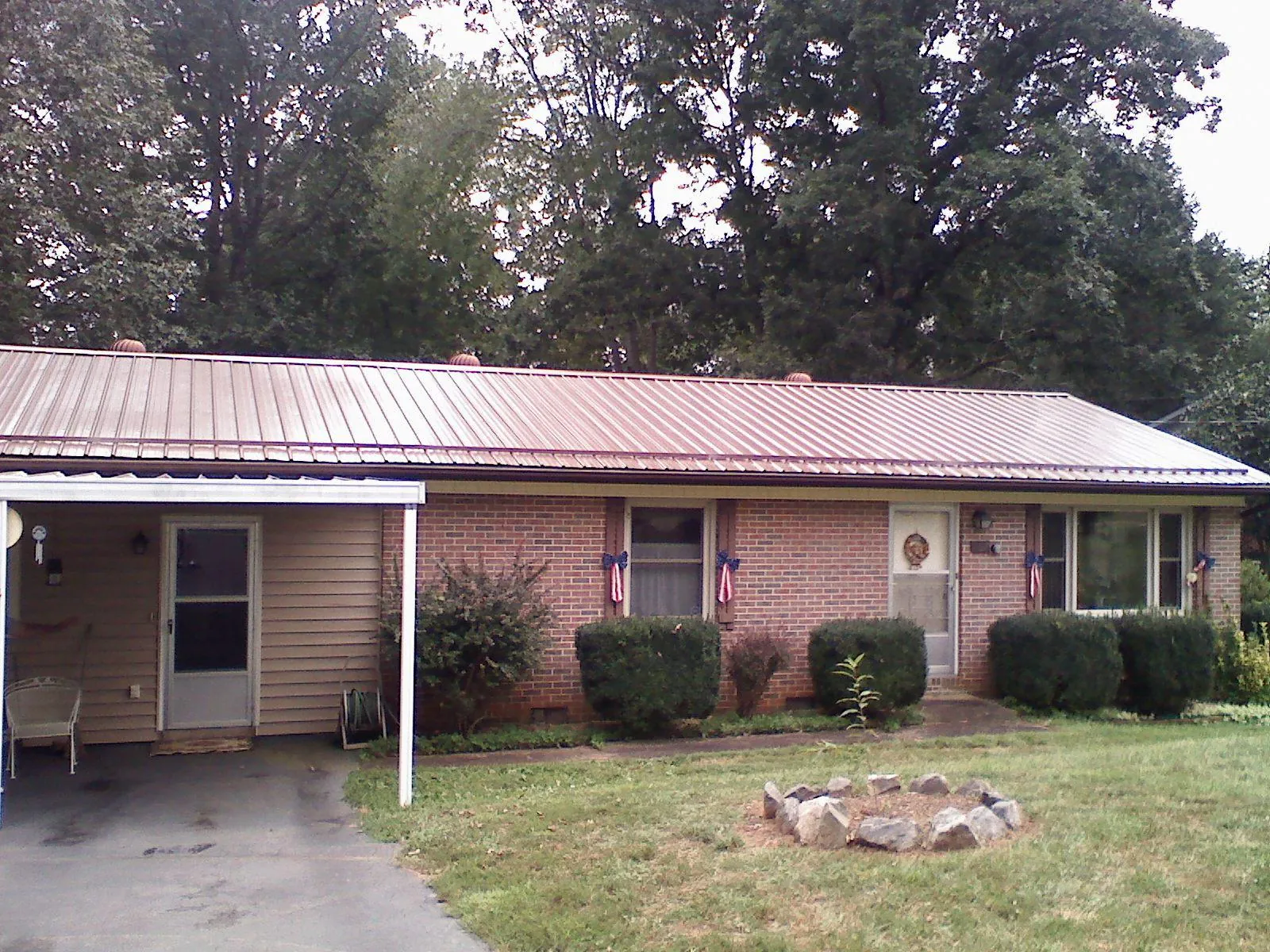 Bronze metal roof and carport on a brick ranch home — Roof Repair work by our crew in Idledale